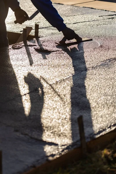 Trabajador de la construcción suavizando el cemento húmedo con herramientas de paleta — Foto de Stock