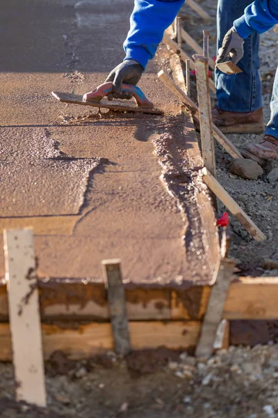 Ciment humide de lissage de travailleur de la construction avec des outils de truelle — Photo