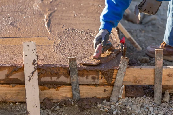 Работник строительства сглаживание мокрого цемента с помощью лопаточных инструментов — стоковое фото