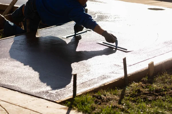 Trabajador de la construcción suavizando el cemento húmedo con herramientas de paleta — Foto de Stock