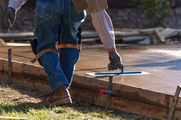 Bauarbeiter glättet nassen Zement mit Spachtelwerkzeug — Stockfoto