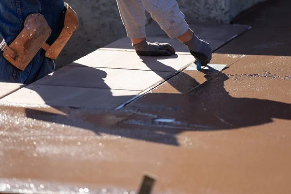 Trabajador de la construcción suavizando el cemento húmedo con la herramienta de borde de mano — Foto de Stock