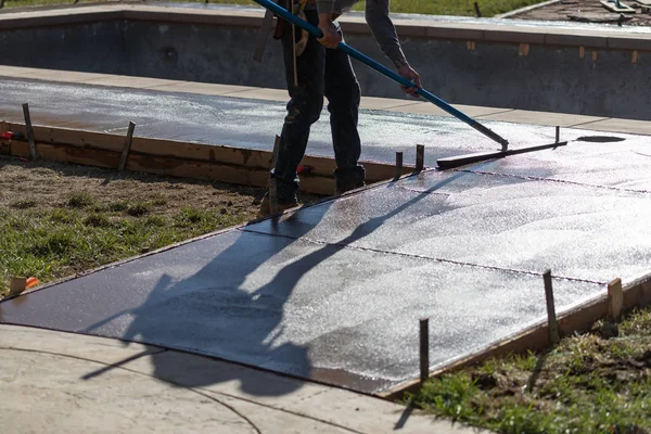 Trabajador de la construcción suavizando el cemento húmedo con herramienta de paleta — Foto de Stock