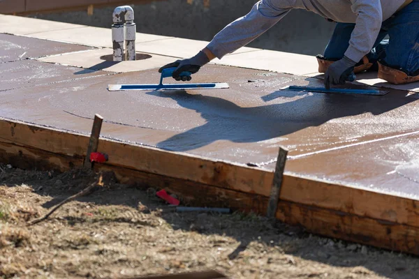 Trabajador de la construcción suavizando el cemento húmedo con herramientas de paleta — Foto de Stock