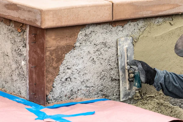 Trabalhador da telha aplicando cimento com espátula na construção da piscina Sit — Fotografia de Stock