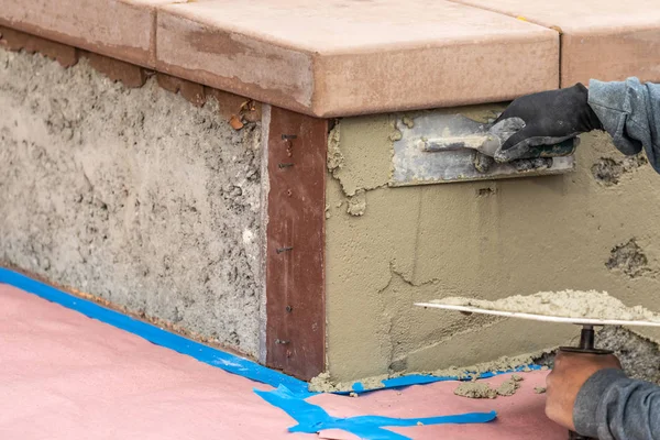 Azulejo trabajador aplicación de cemento con paleta en la construcción de la piscina Sit — Foto de Stock