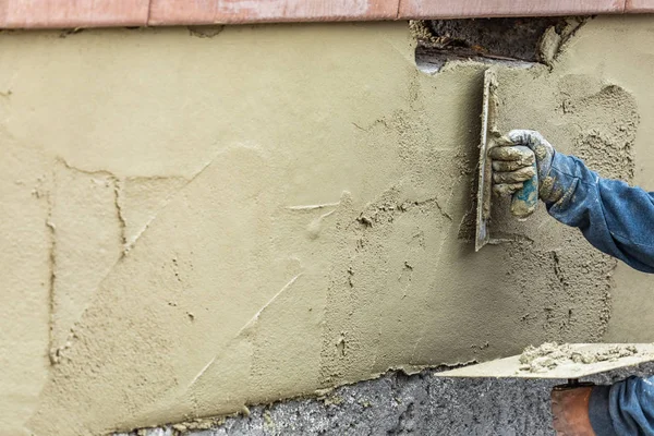 Trabalhador da telha aplicando cimento com espátula na construção da piscina Sit — Fotografia de Stock