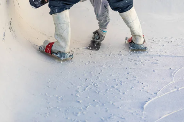 Trabalhador vestindo sapatos cravados alisamento molhado piscina gesso com passarinho — Fotografia de Stock