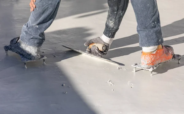 Arbeiter mit Stachelschuhen glätten nassen Poolputz mit Trog — Stockfoto