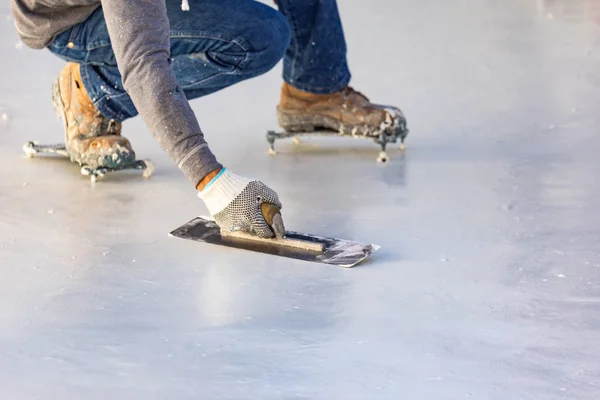 Arbetare bär spetsiga skor utjämning våt pool med trow — Stockfoto