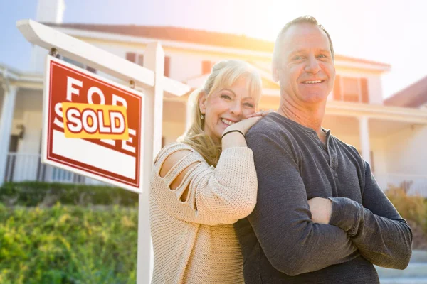 Atraktivní pár středního věku v předním domě a nápis-prodej nemovitostí — Stock fotografie