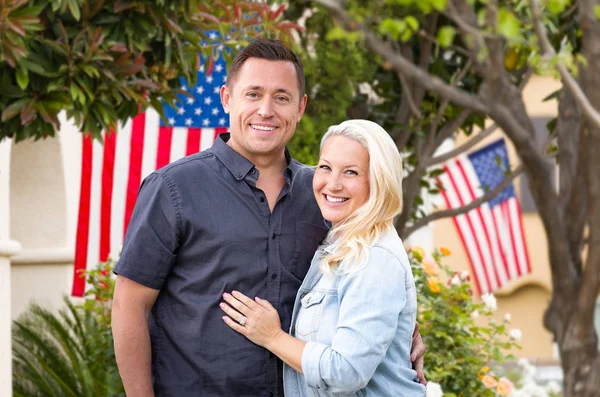 Couple heureux devant des maisons avec des drapeaux américains — Photo