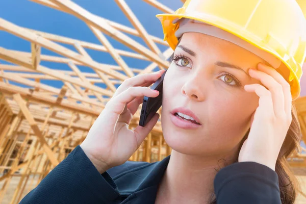 Обеспокоенная женщина-подрядчик в жесткой шляпе с помощью мобильного телефона на строительной площадке — стоковое фото