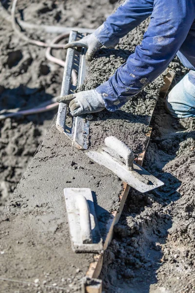 Trabalhador da construção da associação que trabalha com uma haste mais lisa no concreto molhado — Fotografia de Stock