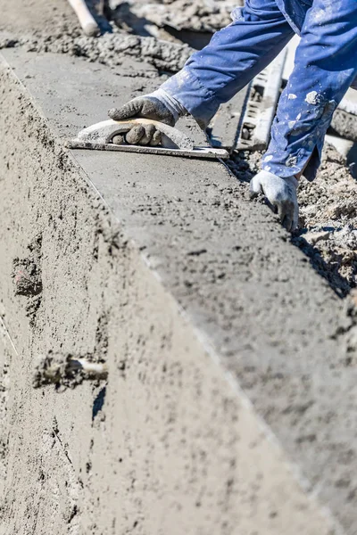 Pool byggnadsarbetare som arbetar med trä flyta på våt betong — Stockfoto