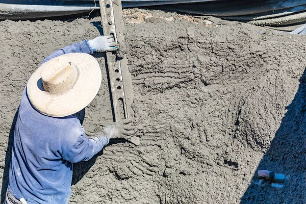 Trabajador de construcción de piscinas que trabaja con una varilla más suave en hormigón húmedo — Foto de Stock