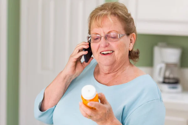 Femme adulte âgée sur téléphone cellulaire tenant bouteille d'ordonnance — Photo