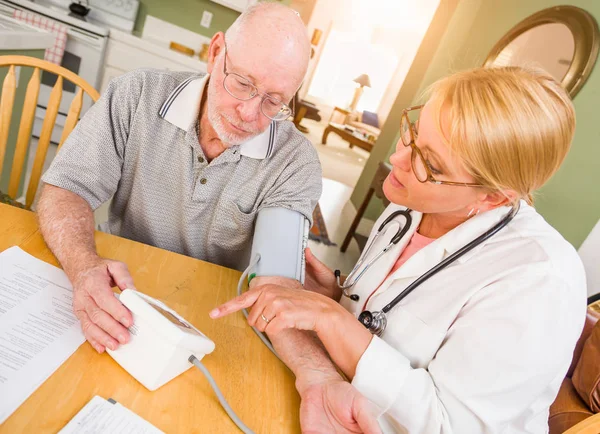 Enfermera o médico que ayuda al hombre adulto mayor a tomar la presión arterial en casa . — Foto de Stock