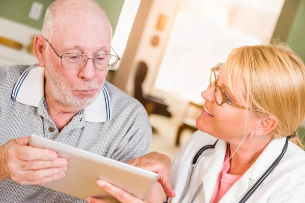 Ärztin oder Krankenschwester zeigt Senioren Touchpad-Computer zu Hause. — Stockfoto