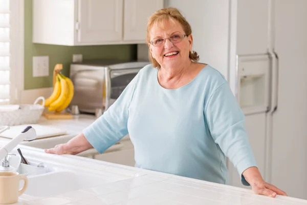 Retrato de uma mulher adulta sênior sorridente bonita na cozinha — Fotografia de Stock