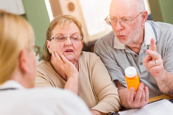 Médico o enfermera explicando medicamentos recetados a pareja adulta mayor . — Foto de Stock