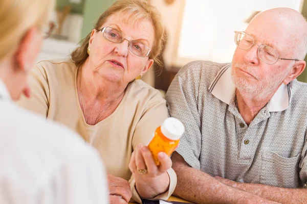 Medico o infermiere che spiegano la medicina di prescrizione alla coppia adulta anziana . — Foto Stock