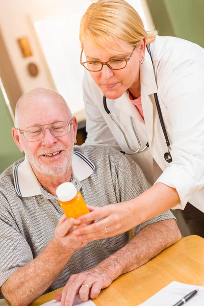 Médico o enfermera explicando la medicina de la prescripción al hombre mayor atento . —  Fotos de Stock