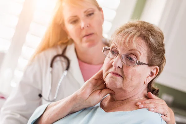 Melancólica mujer adulta mayor siendo consolada por una doctora o enfermera . — Foto de Stock