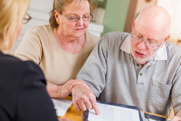 Couple d'adultes âgés passant en revue les documents dans leur maison avec Agen — Photo