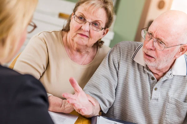 Senior volwassen paar gaan over documenten in hun huis met Agen — Stockfoto