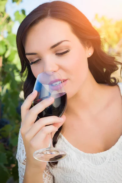 Hermosa mujer joven adulta disfrutando de una copa de cata de vino en el viñedo — Foto de Stock