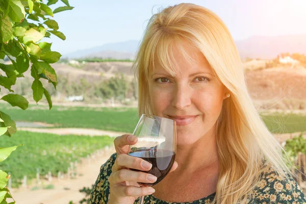 Hermosa mujer joven adulta disfrutando de una copa de cata de vino en el viñedo — Foto de Stock