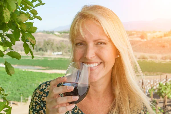 Hermosa mujer joven adulta disfrutando de una copa de cata de vino en el viñedo — Foto de Stock