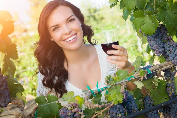 Όμορφη νεαρή ενήλικη γυναίκα απολαμβάνει ένα ποτήρι γευσιγνωσίας κρασιού στον αμπελώνα — Φωτογραφία Αρχείου
