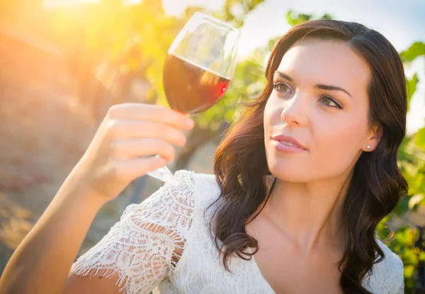 Mulher adulta jovem bonita desfrutando de um copo de degustação de vinhos na vinha — Fotografia de Stock