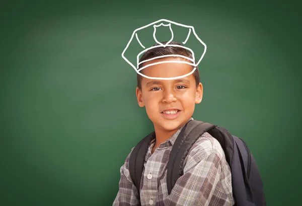 Joven estudiante hispano usando mochila frente a pizarra con sombrero de policía dibujado en tiza sobre la cabeza —  Fotos de Stock
