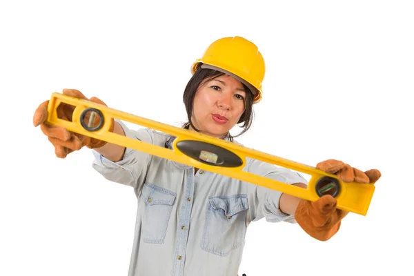 Hispânico feminino contratante segurando nível vestindo chapéu duro isolado em fundo branco . — Fotografia de Stock