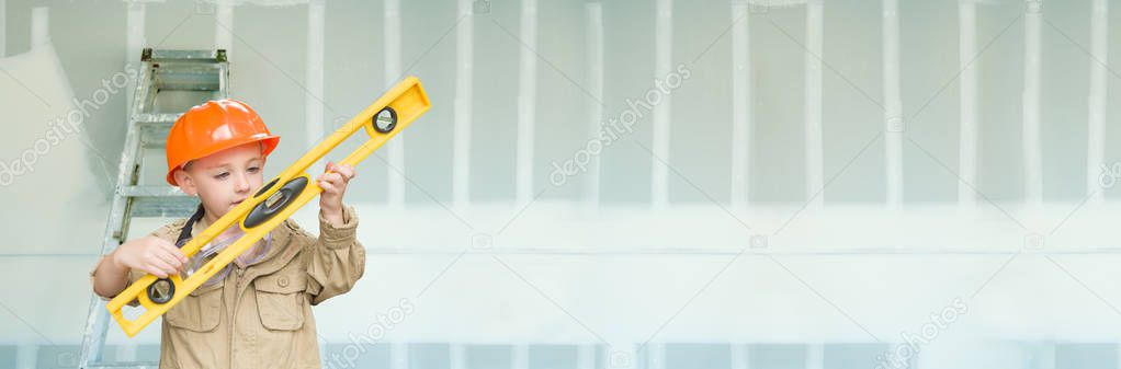 Cute Young Boy Dressed As Contractor Holding Level Against Dywall Banner Background with Ladder.