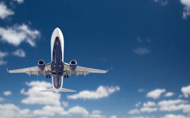 Bottom View of Passenger Airplane Flying In The Blue Sky clipart