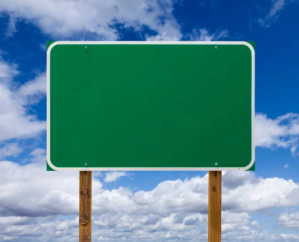 Blank Green Road Sign with Wooden Posts Over Blue Sky and Clouds — Stock Photo, Image