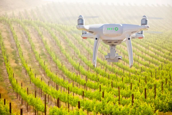 Unmanned Aircraft System (UAV) Quadcopter Drone In The Air Over Grape Vineyard Farm.
