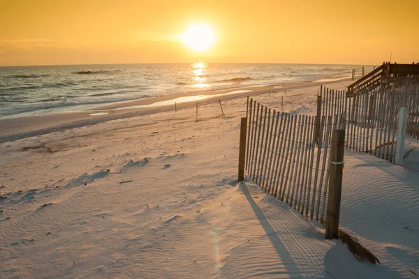 Prachtige zonsondergang over de oceaan met zand hekwerk — Stockfoto