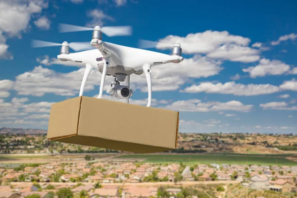 Sistema de aviones no tripulados (UAS) Drone Quadcopter que lleva el paquete en blanco sobre el vecindario —  Fotos de Stock