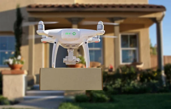 Neobsazený letecký systém (UAV) Čtyřkopter Drone dodávající balíček k domu — Stock fotografie