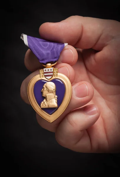 Чоловіча рука тримає збройні сили пурпурного медаль серця — стокове фото