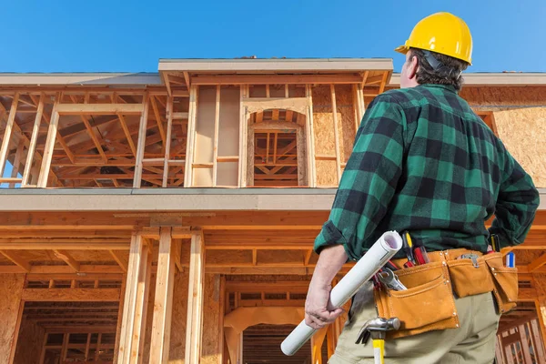 Contratista en frente de la nueva casa de madera en el sitio de construcción — Foto de Stock