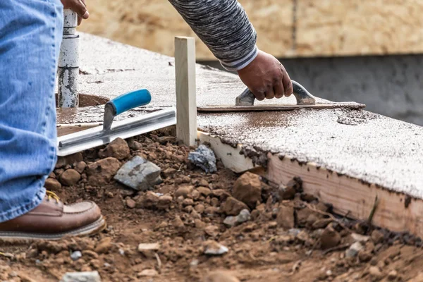 Byggarbetare med hjälp av trätråg på våt cement bildar hantera runt ny pool — Stockfoto