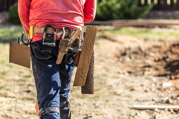 Travailleur de la construction de ciment avec ceinture à outils tenant diverses truelles et outils sur la ceinture — Photo