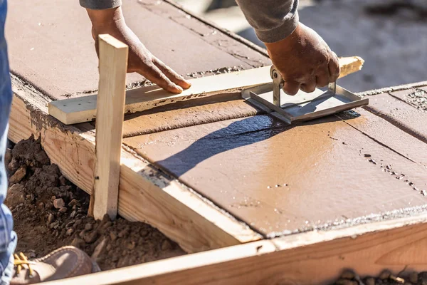 Bauarbeiter mit Hand-Groover auf nassem Zementboden beim Bewältigen des neuen Pools. — Stockfoto