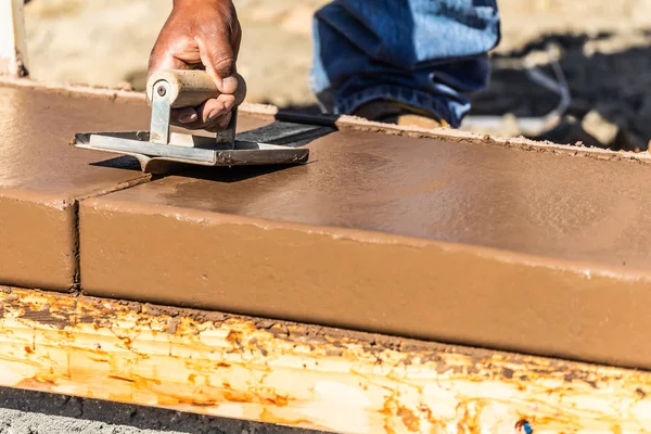 Trabalhador de construção usando mão Groover em cimento molhado formando coping em torno de nova piscina — Fotografia de Stock